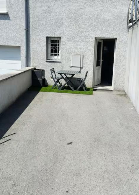 a patio with a table and chairs in front of a building at Appartement Bois de doubs in Pontarlier
