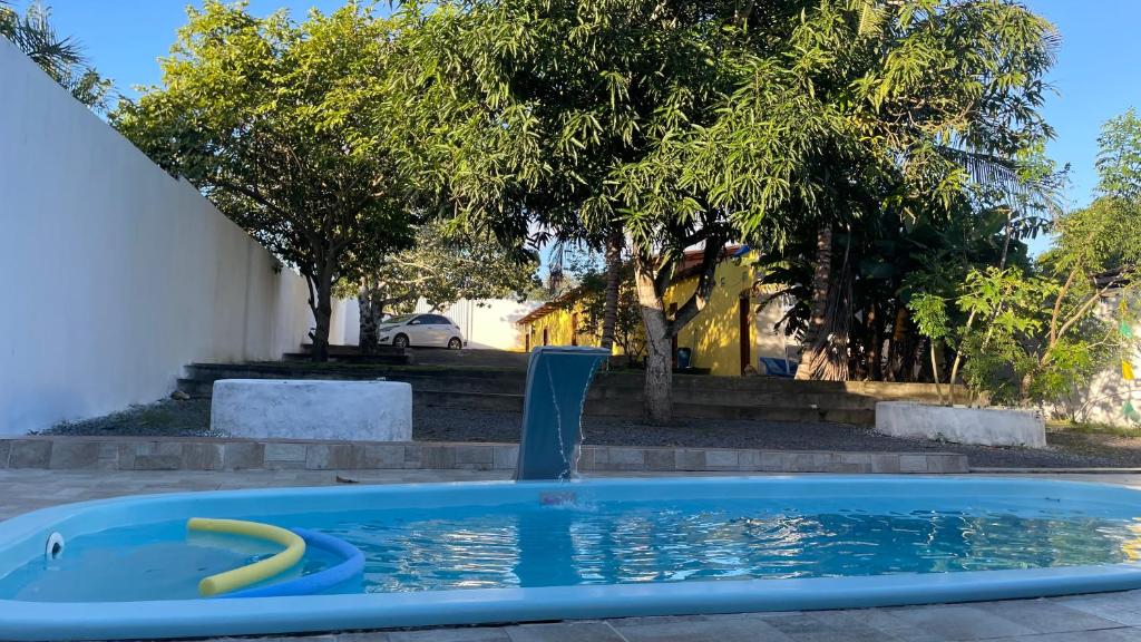 a pool with a yellow hose in a yard at Villa Serrinha - Sitio Paraiso in Serrinha