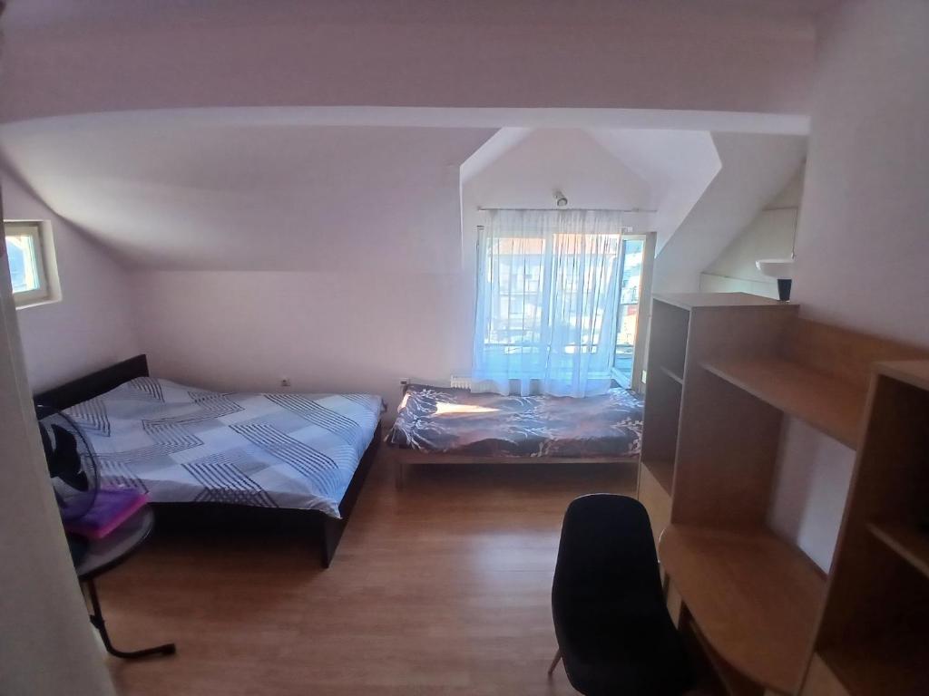 a small room with two beds and a window at Tiha noc apartmani in Belgrade