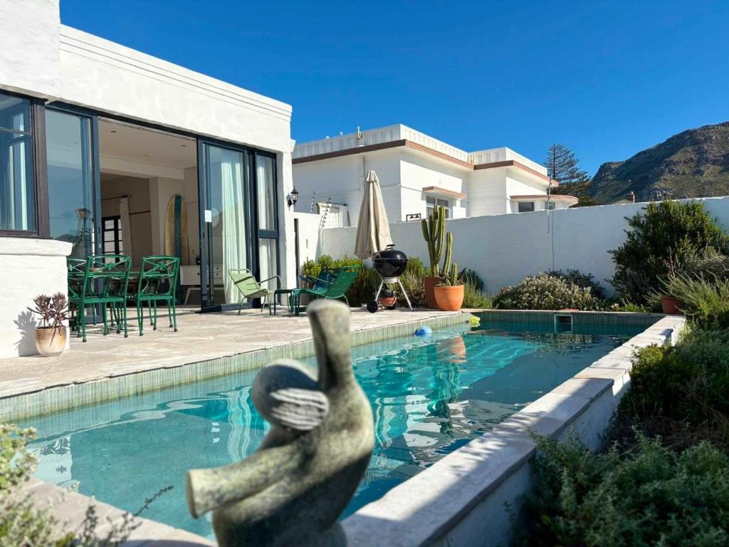 a statue in the water in front of a house at Beach Paradise in Muizenberg