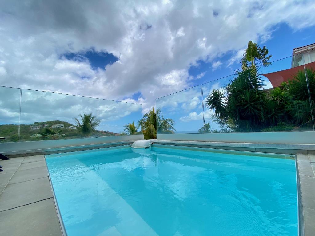 a swimming pool in a house with blue water at Villa APOLLINAIRE in Les Trois-Îlets