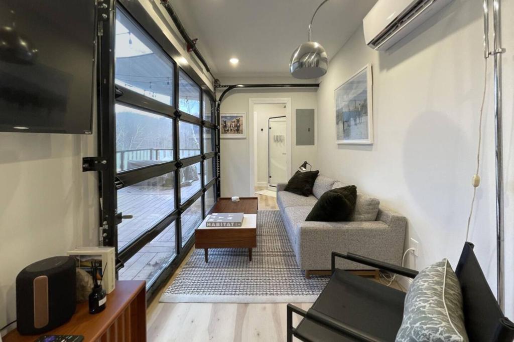 a living room with a couch and a tv at The Hideaway on Tacketts - Shipping Container in Hurricane