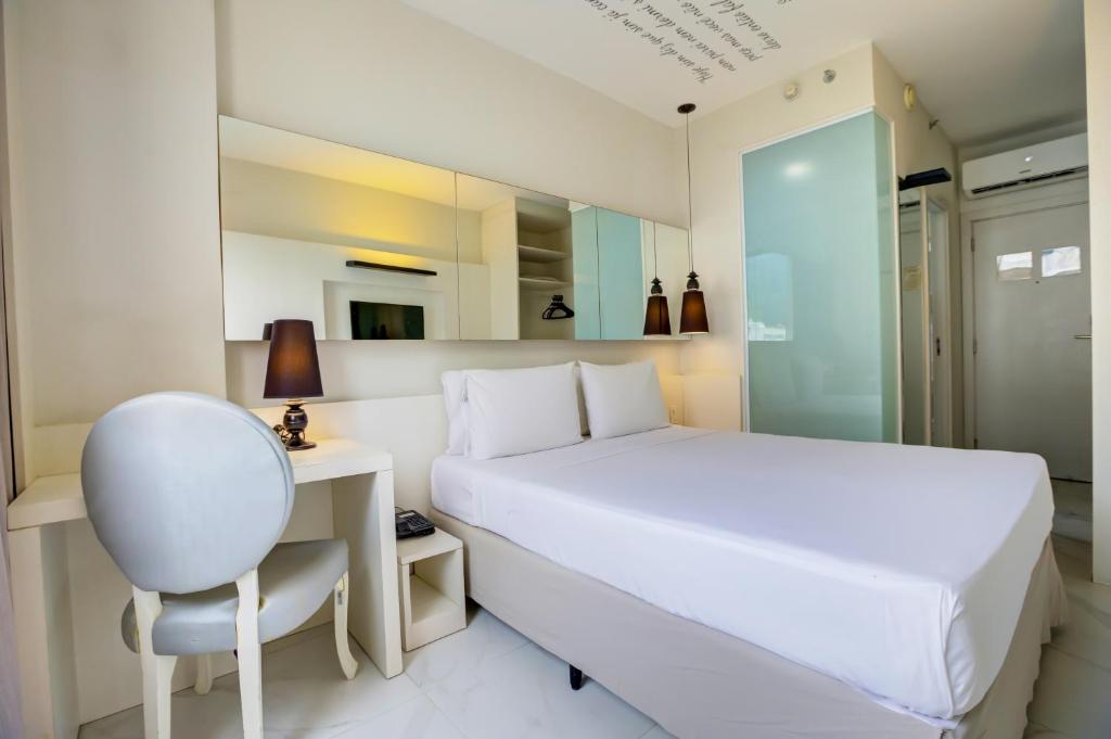 a bedroom with a bed and a desk and a chair at Aera Rio de Janeiro Copacabana in Rio de Janeiro