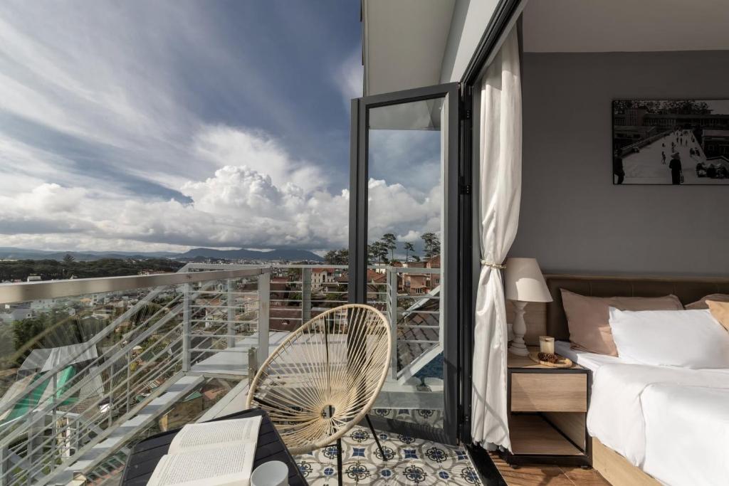 a bedroom with a balcony with a fan at Gia Nguyễn Hotel Dalat in Da Lat