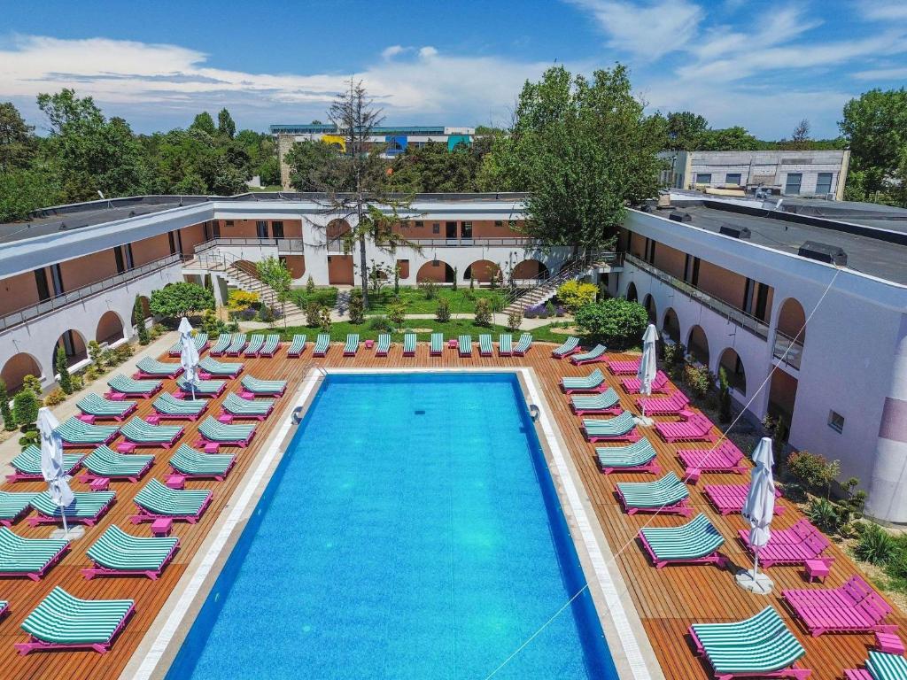 an overhead view of a pool with chaise lounge chairs and a resort at ibis Styles Venus in Venus