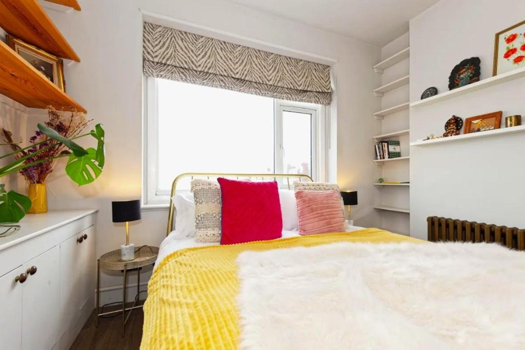 a bedroom with a bed with colorful pillows on it at Walpole Bay Sea Views in Margate