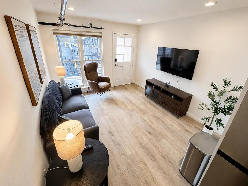 a living room with a couch and a flat screen tv at The Accessible Atom | Historic Main in St. Charles