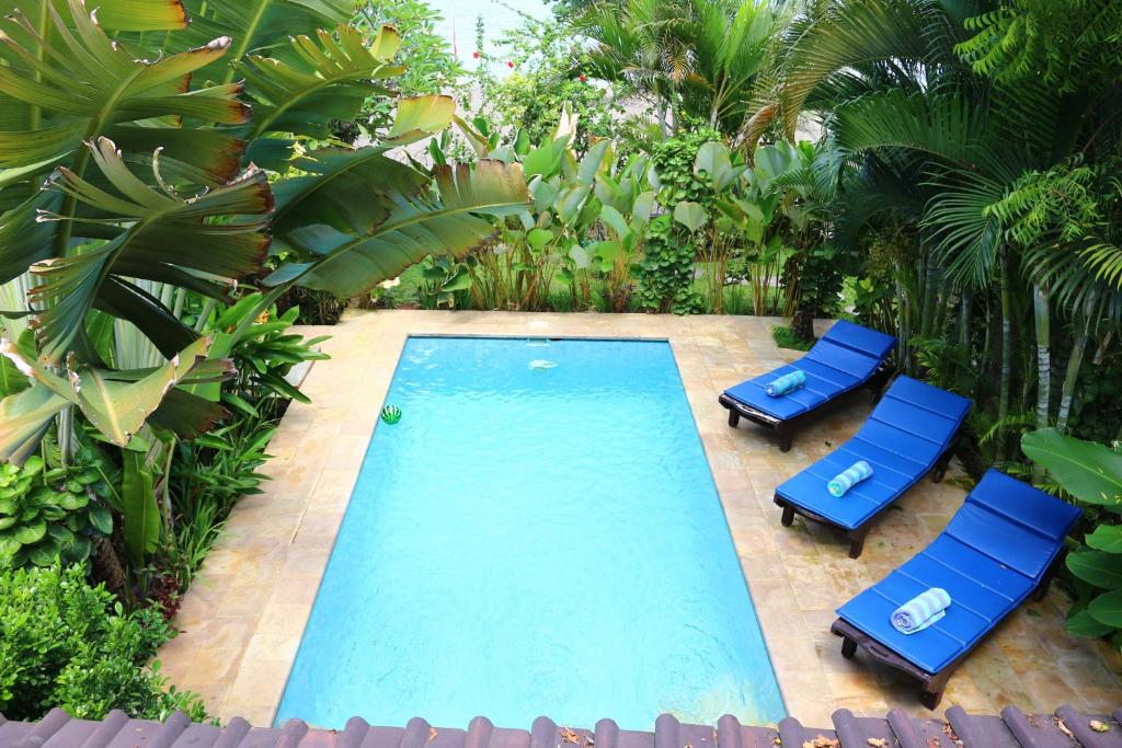 an overhead view of a swimming pool with two blue chairs at Lovina Beachhouse Villas in Lovina