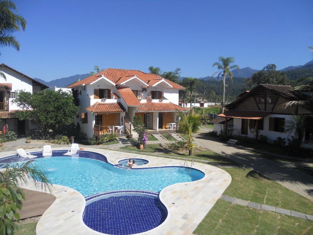 a swimming pool in front of a house at Recanto da Praia in Paraty