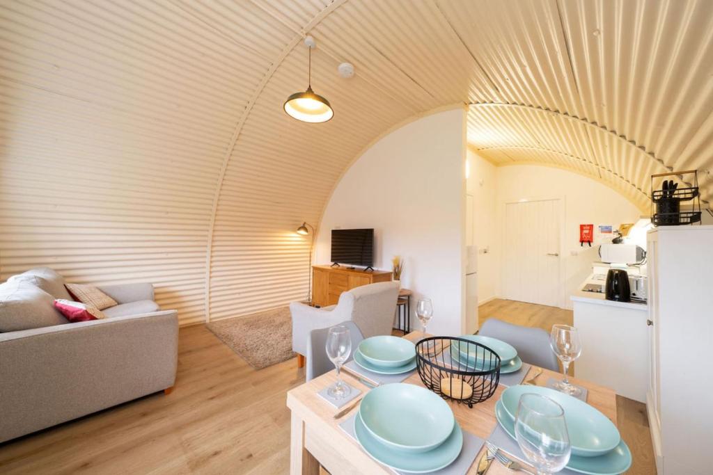 a living room with a couch and a table at Cultybraggan Hut 38 - Accessible in Comrie