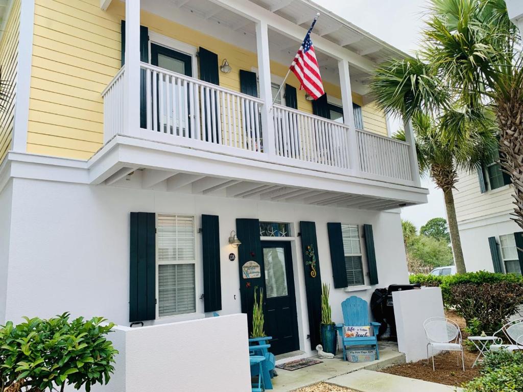 a white house with a balcony and an american flag at Bungalows at Seagrove #138 in Seagrove Beach