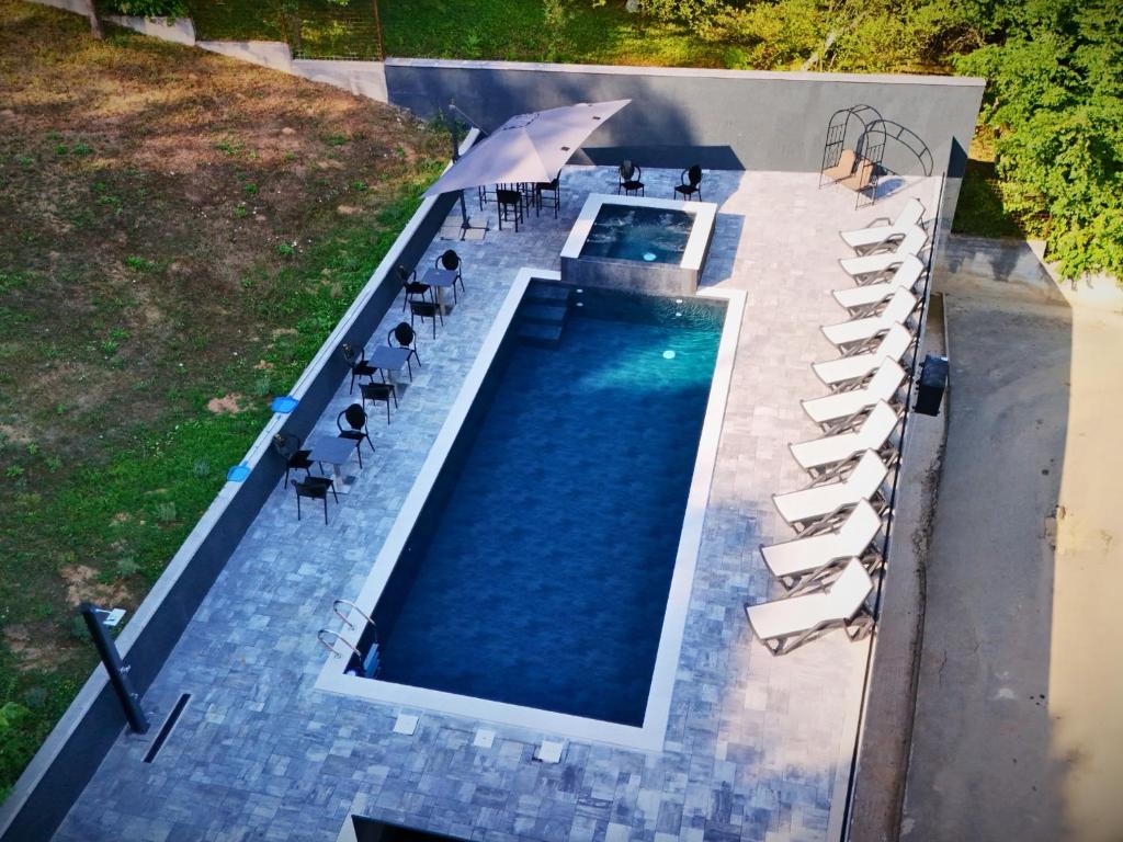 an overhead view of a swimming pool with chairs and an umbrella at Kuća za odmor Đogić - bazen & jacuzzi in Ilidža