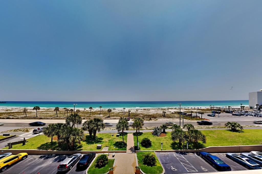 a parking lot with cars parked in front of the beach at Sabine Yacht & Racquet #5F in Pensacola Beach