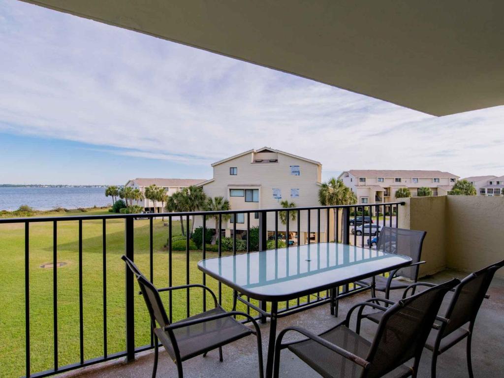 a table and chairs on a balcony with a view of the ocean at Santa Rosa Dunes #1022 in Pensacola Beach
