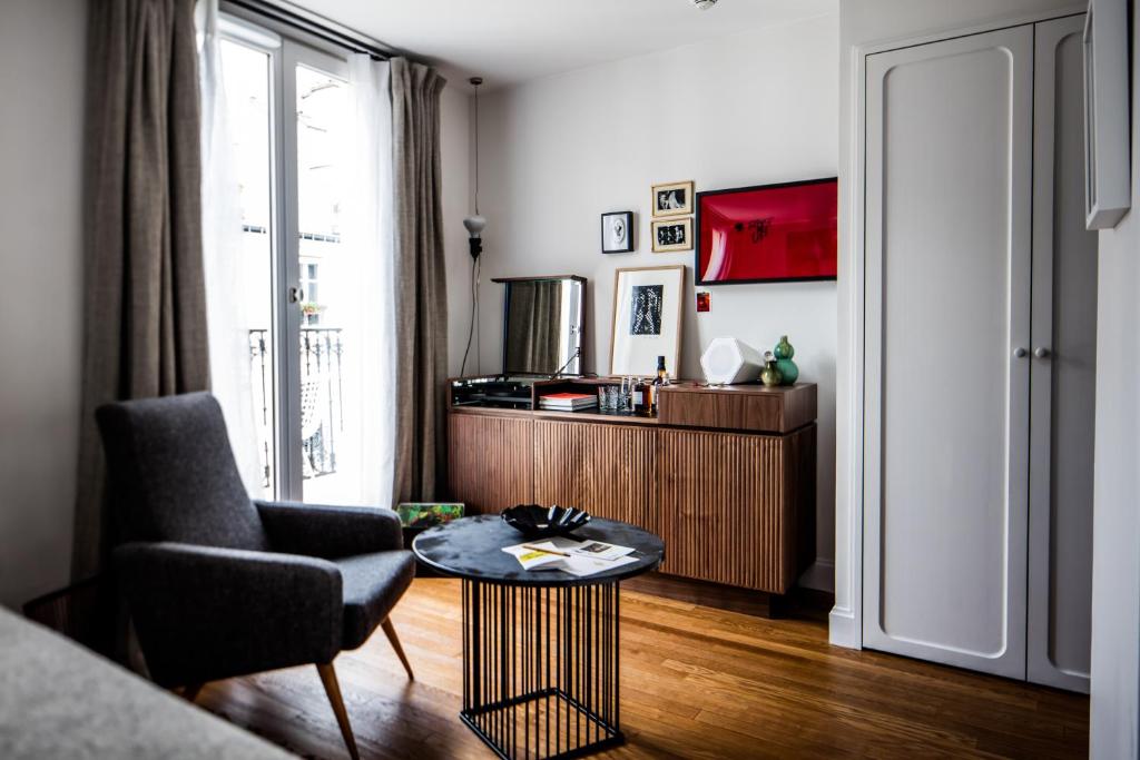 a living room with a table and a chair at Le Pigalle, a Member of Design Hotels in Paris