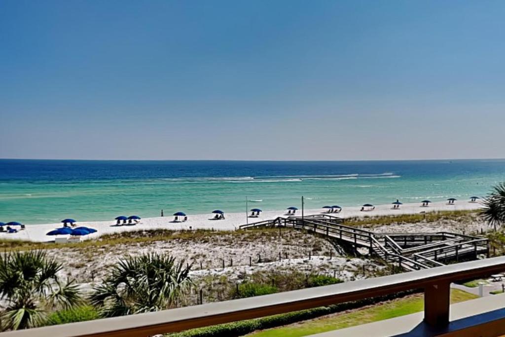a beach with a bunch of umbrellas and the ocean at Aegean #332 in Destin
