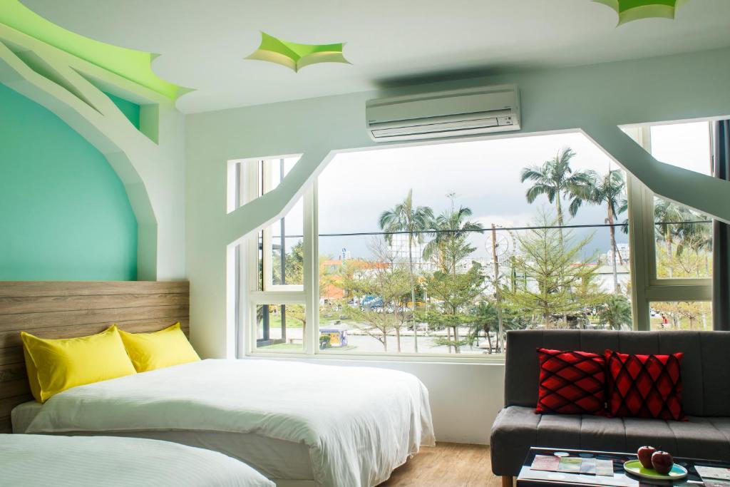een slaapkamer met een bed en een raam bij Apple Tree Bed and Breakfast in Hualien