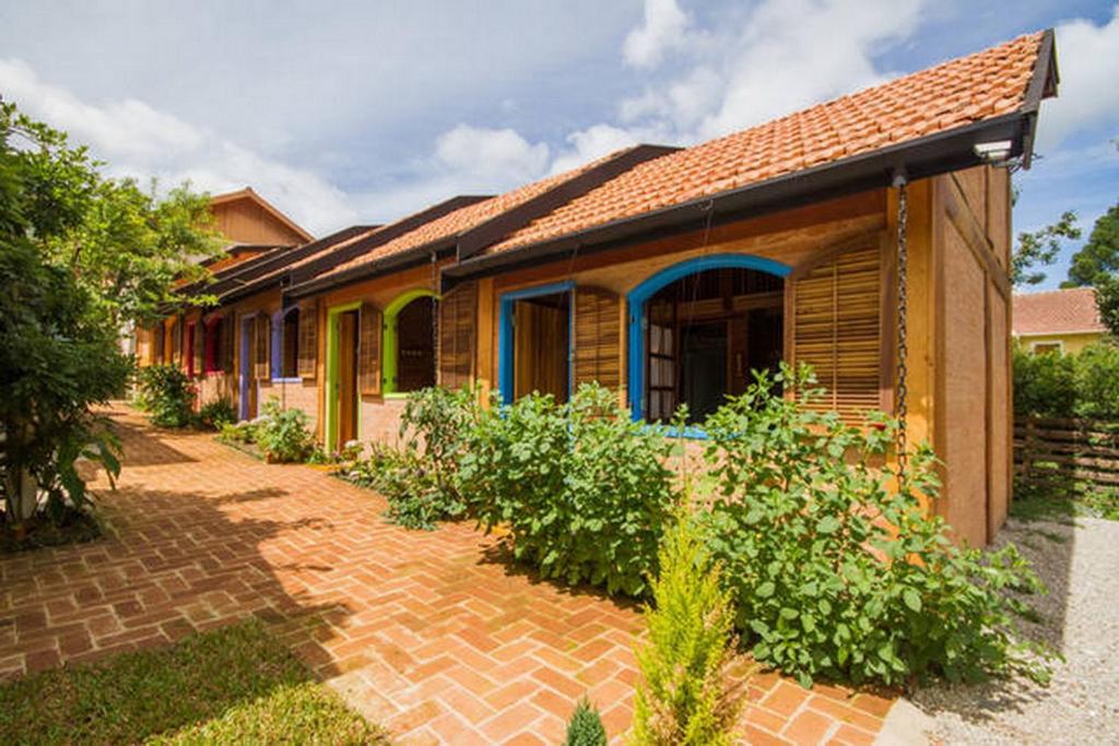 a house with a brick walkway in front of it at Vila Báltica Chalés in Campos do Jordão