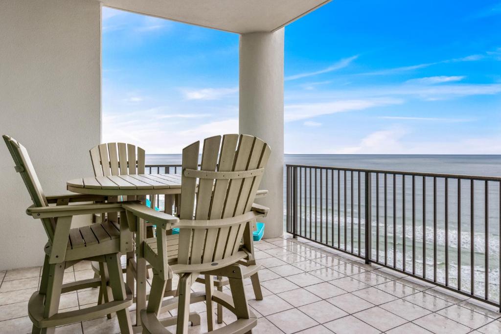 two chairs and a table on a balcony with the ocean at The Oasis at Orange Beach 1707 in Orange Beach