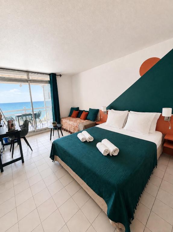 a bedroom with a large bed with towels on it at Studio Vigie 212 vue mer, accès piscine in Le Diamant