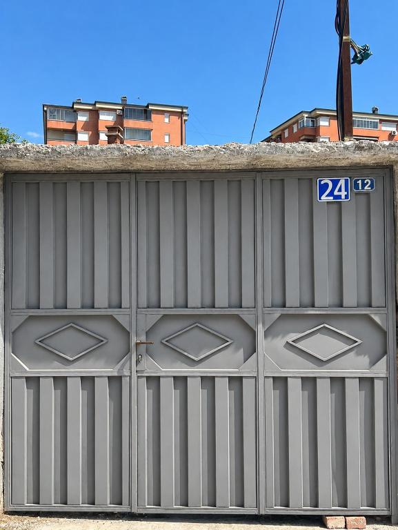 a metal garage door with the number on it at Peja Riverside Hostel in Peje