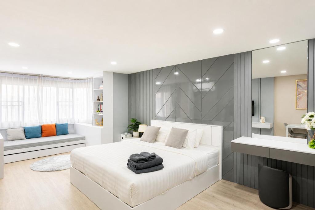 a white bedroom with a large bed and a bathroom at Sweet room in Nimnan in Chiang Mai