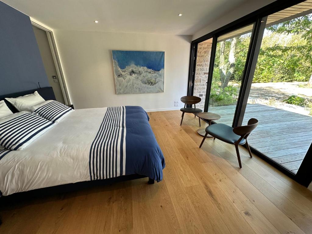 a bedroom with a bed and a large window at Er Rohellec in Baden