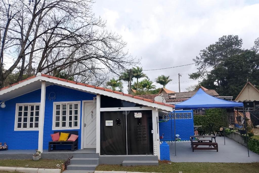 a blue tiny house with a porch and a table at Chale ITU -Camping Carrion - Tomorrowland in Itu