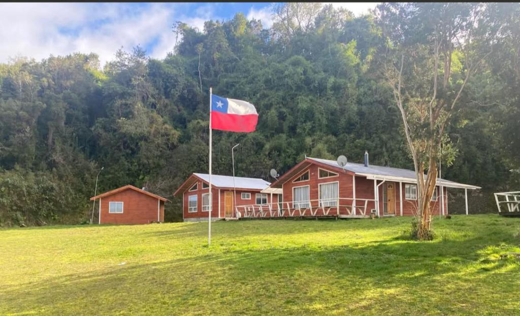 a flag in front of a house in a field at Cabañas El Rincon del Sur in Colaco