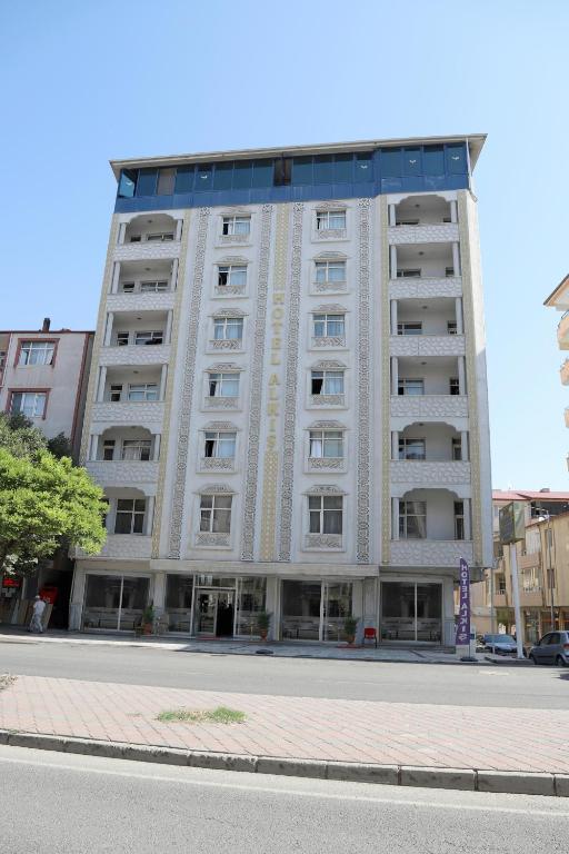 a tall white building on a city street at Alkış Otel in Iğdır