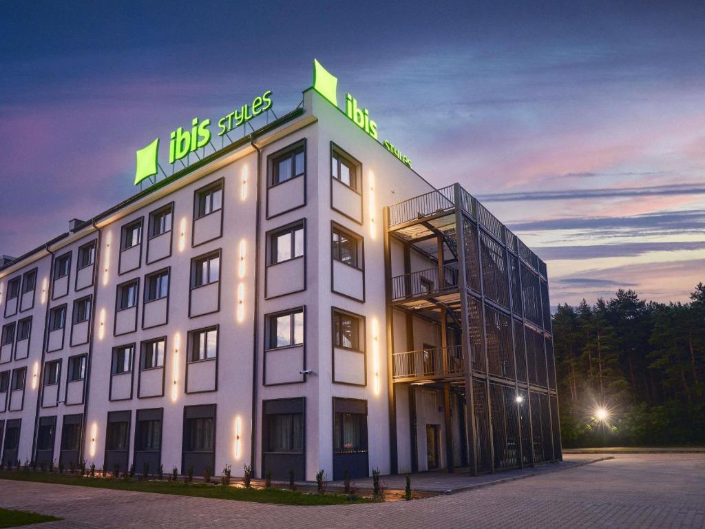 a large white building with a sign on it at ibis Styles Katowice Airport in Pyrzowice