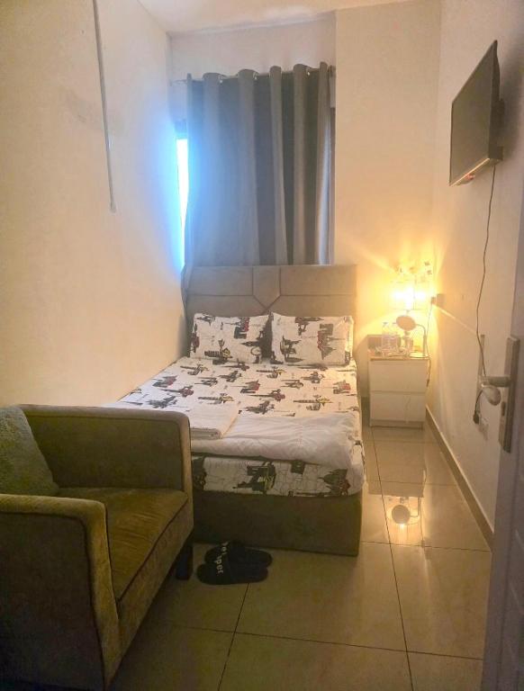 a small bedroom with a bed and a couch at Dream International City Homes in Dubai