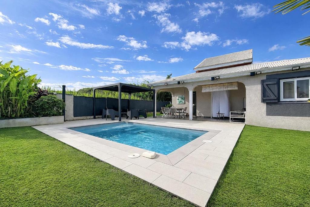 a swimming pool in the yard of a house at Private Villa, Castel in Lamentin