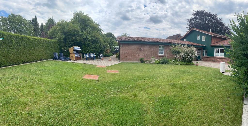 a backyard of a house with a yard sidx sidx sidx at Ferienwohnung "Haaler Au" in Haale