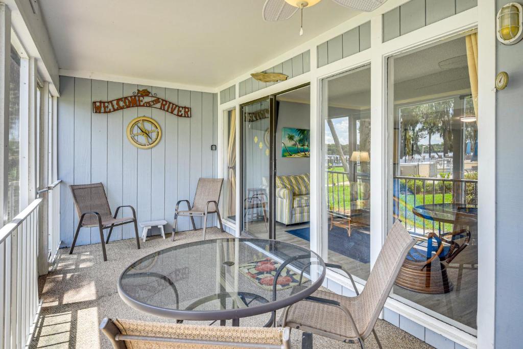a patio with a glass table and chairs on a porch at Boat Dock, Slips & Pool! St Johns River Condo in Welaka