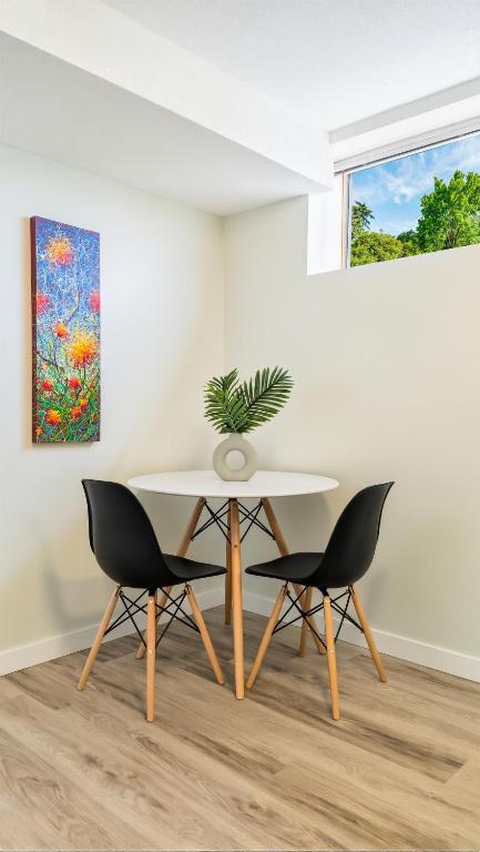 a table and chairs in a room with a painting at Sunny Crest Burnaby-cozy one bedroom private suite in Burnaby