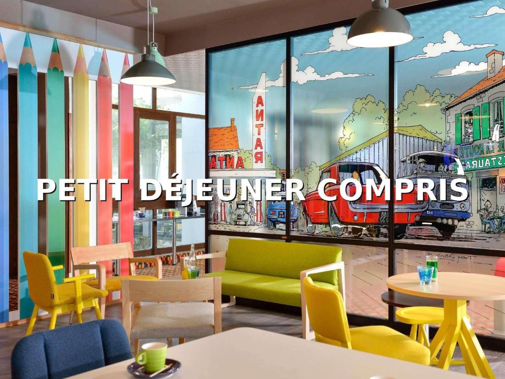 a restaurant with a mural of a train on the wall at ibis Styles Angoulême Nord in Champniers