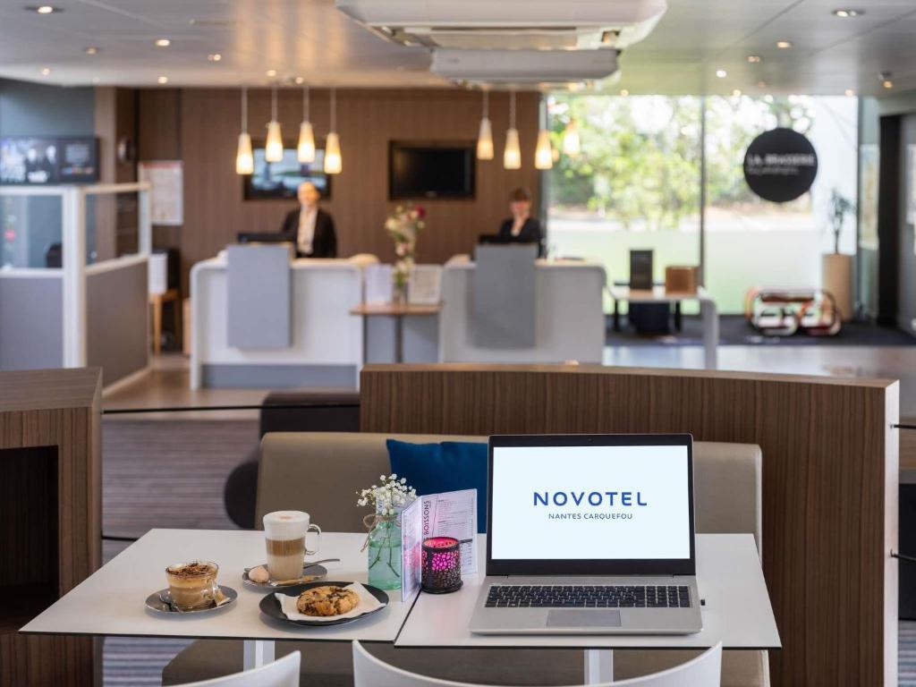 a laptop computer sitting on a table in a restaurant at Novotel Nantes Carquefou in Carquefou