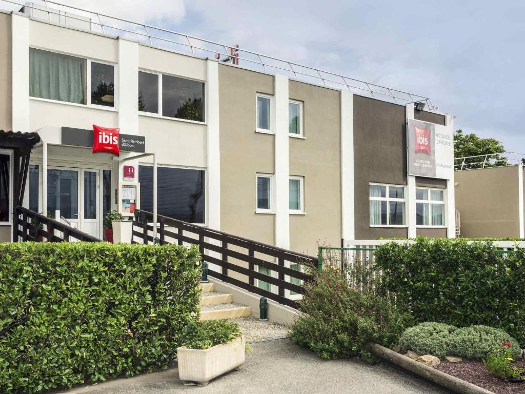 a building with a gas station in front of it at ibis Lyon Sud Saint-Rambert-d'Albon in Saint-Rambert-dʼAlbon