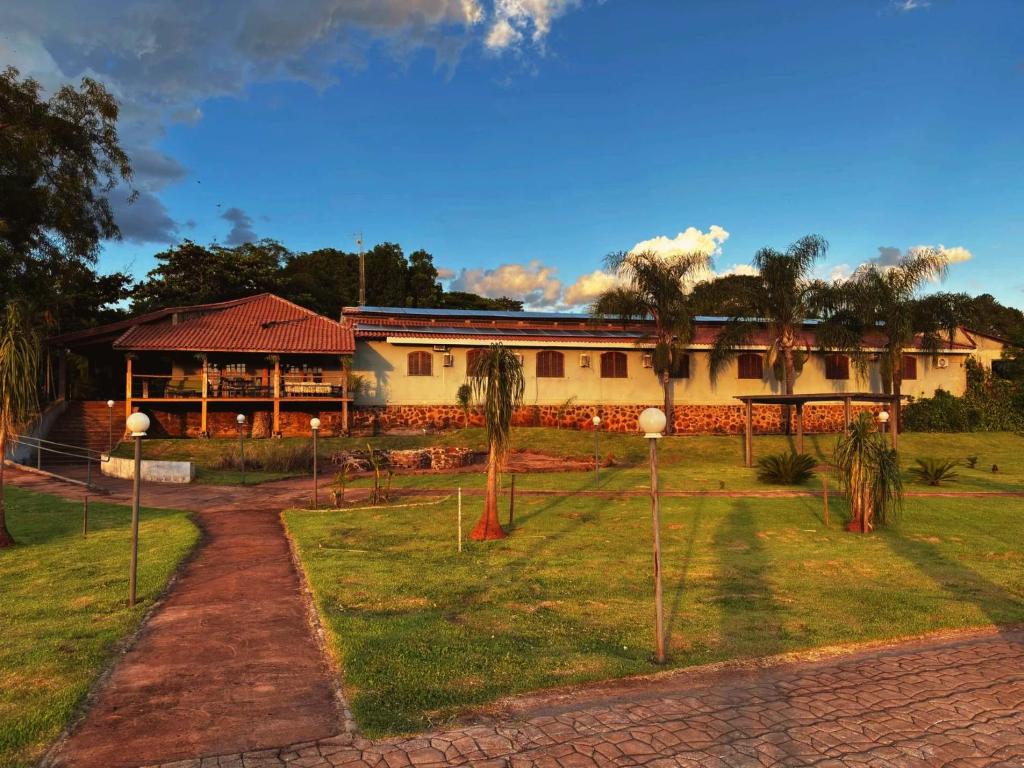 a building with palm trees in front of it at Fazenda Itaygua Hotel in Ribeirão Preto