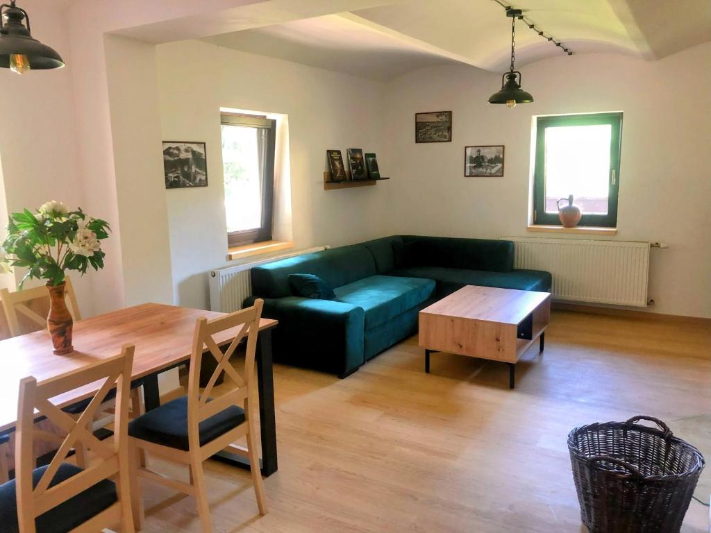 a living room with a blue couch and a table at Apartmán Albrechtice 97 in Albrechtice v Jizerských horách