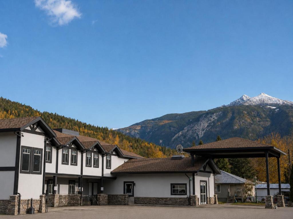 a group of buildings with mountains in the background at Northwinds Hotel Revelstoke in Revelstoke