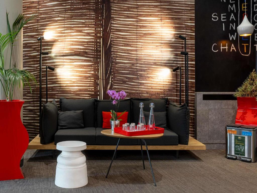 a living room with a black couch and a table at ibis Nancy Centre Gare et Congres in Nancy