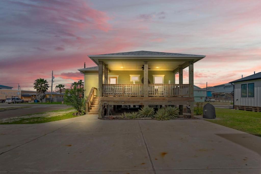 a house with a porch and a sunset at Mills Fishing Cabin in Port Aransas