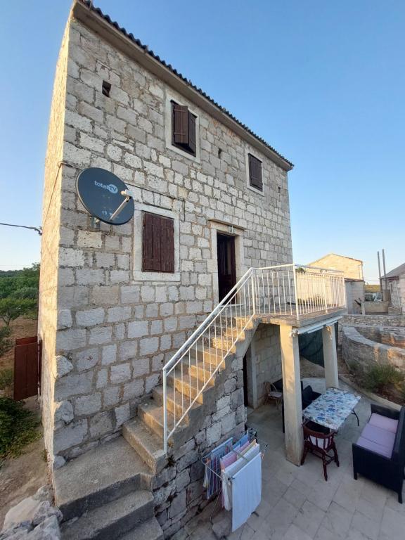 a stone building with a staircase and a stair case at Holiday Home Tomislav in Komiža