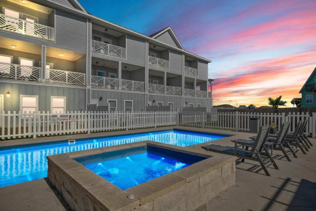 a house with a swimming pool in front of a building at Beach Life in Port Aransas