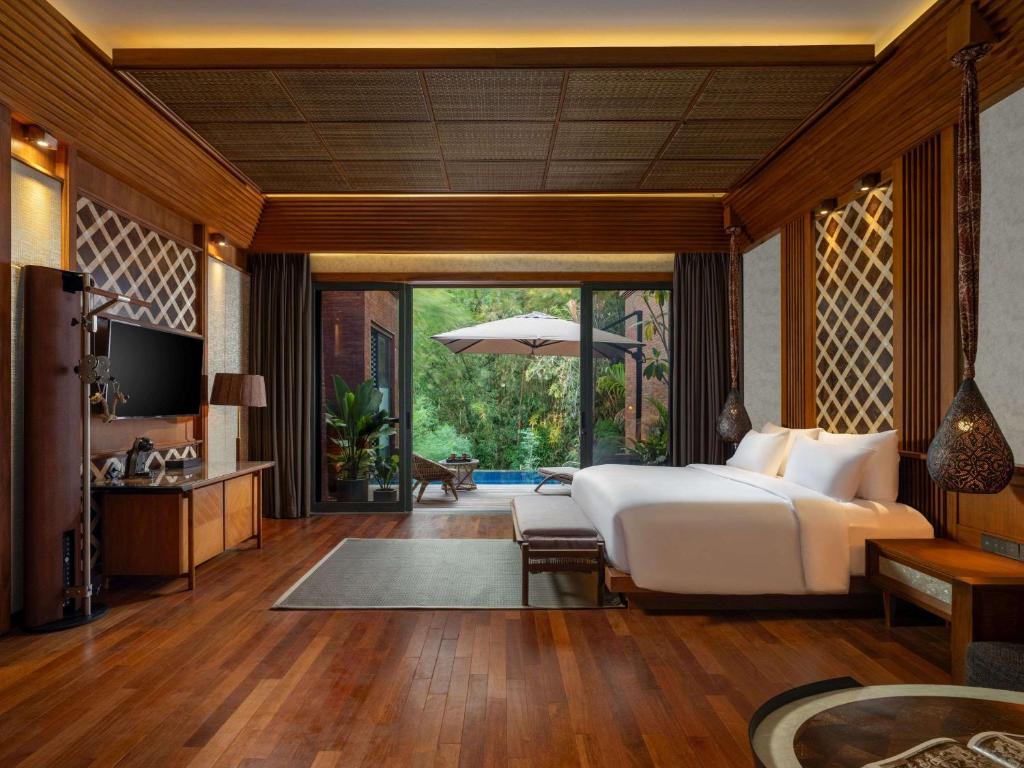 a bedroom with a bed and a living room at Garrya Bianti Yogyakarta in Yogyakarta