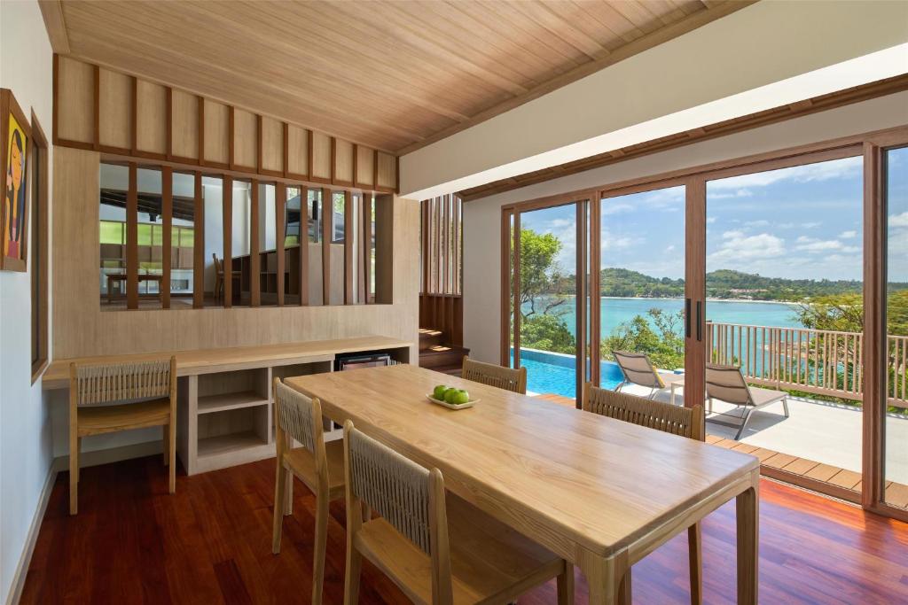 a dining room with a table and a view of the ocean at Garrya Tongsai Bay Samui in Choeng Mon Beach