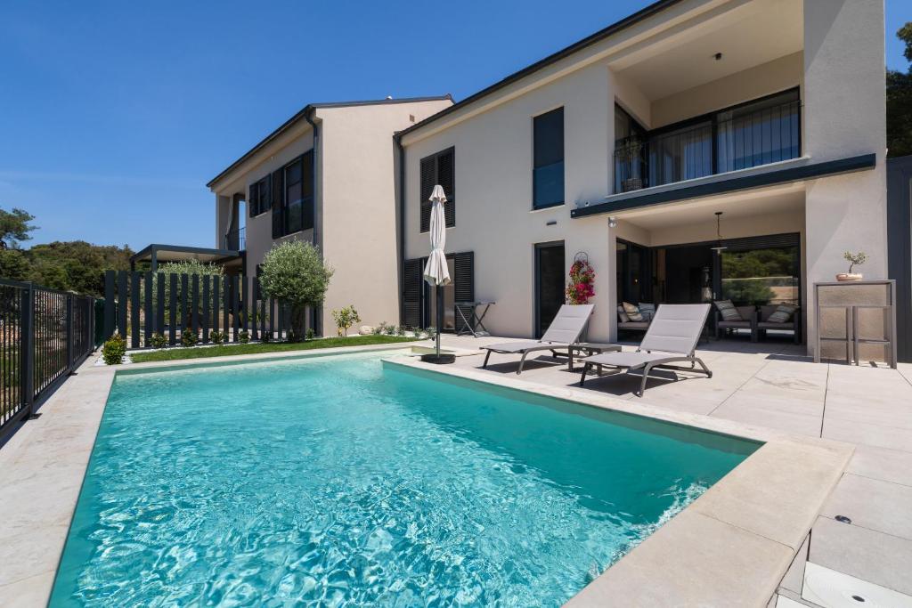 a swimming pool in front of a house at Andrea Deluxe Apartment with Pool in Mali Lošinj