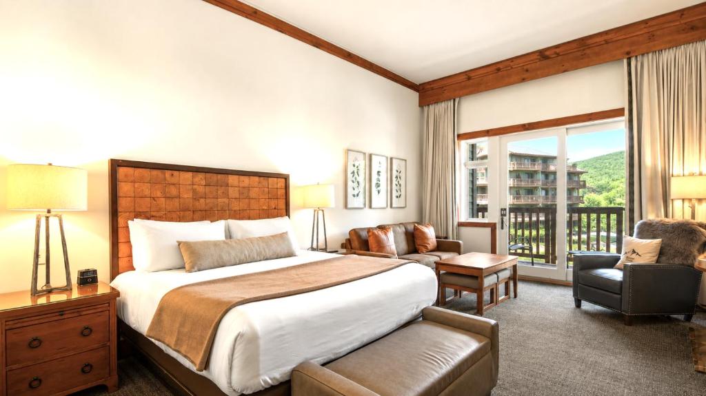 a hotel room with a bed and a balcony at 147 Studio Spruce Peak Lodge at Stowe Mt Resort Sleeps 4 in Stowe